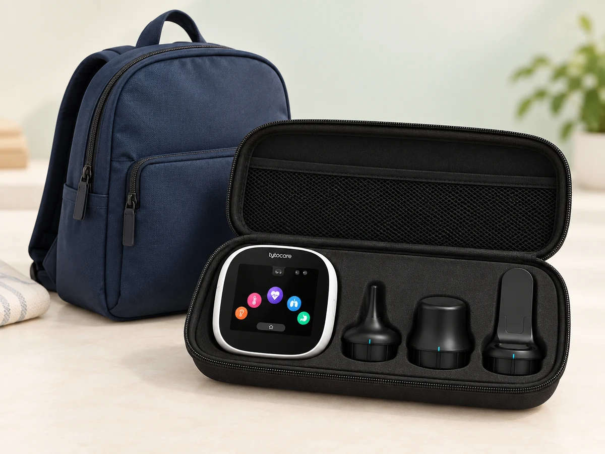 Kit TytoCare con dispositivo y sus tres accesorios, preparado junto a una mochila de viaje